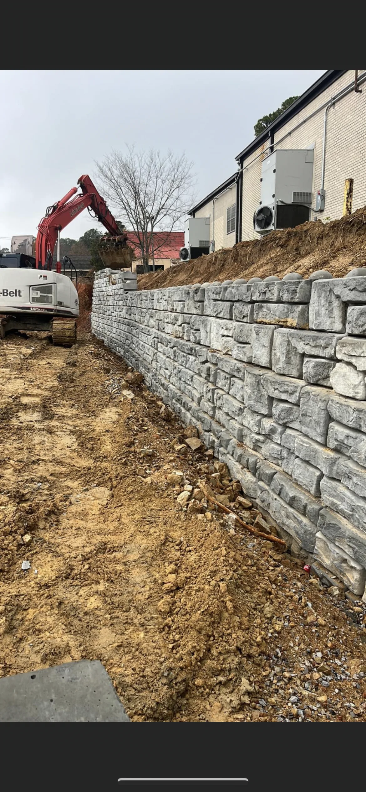Tall block retaining wall along a commercial building